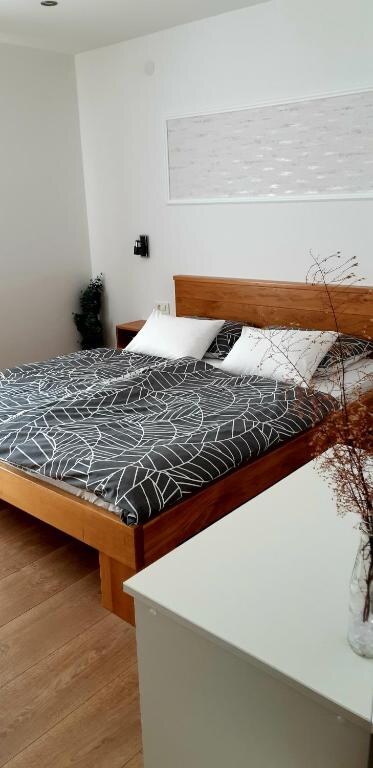 Double bed with fresh linen next to a dresser